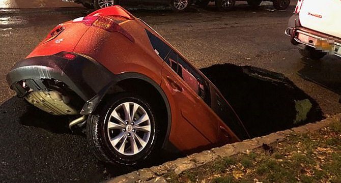 Sokak ortasında aniden oluşan çukur otomobili böyle yuttu