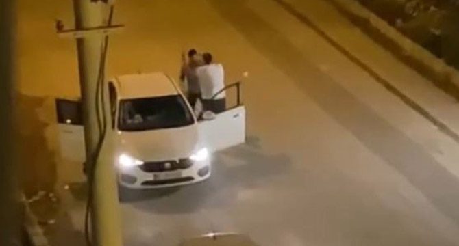 Ayırmaya çalışanlara rağmen araç içindeki kadının yüzüne tekme attı